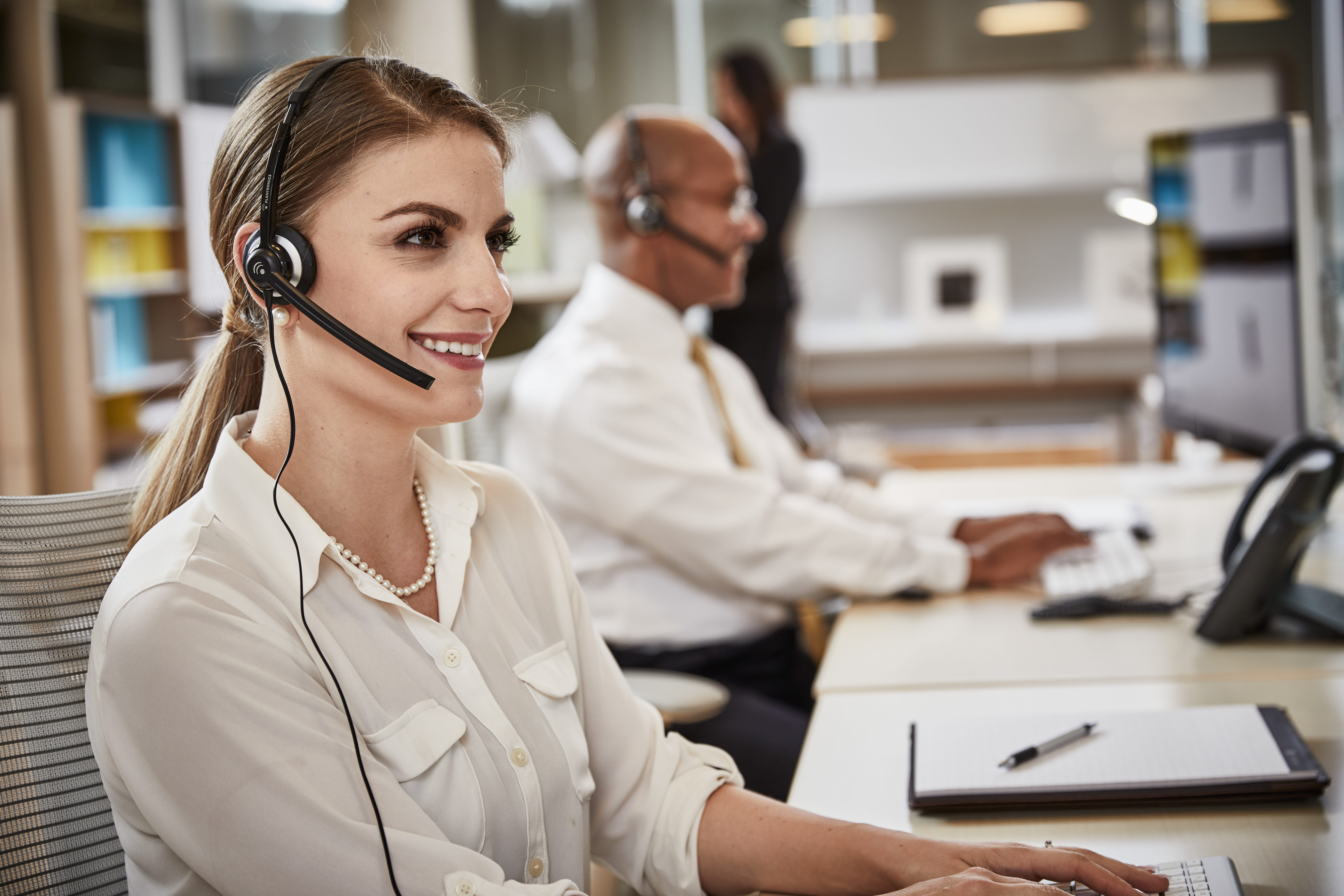 Associate working on a laptop and talking on a headset