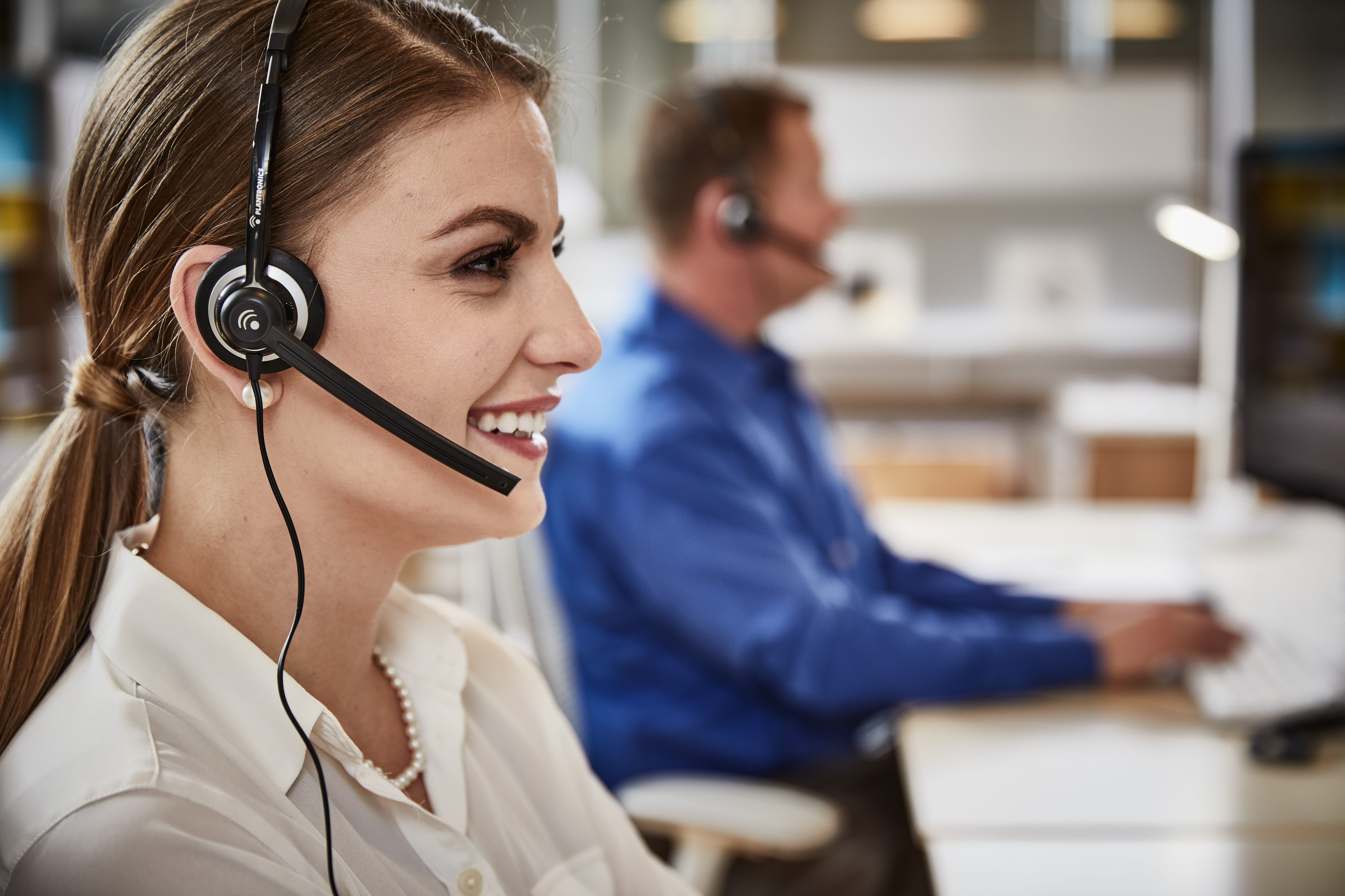 Associate working on a laptop and talking on a headset