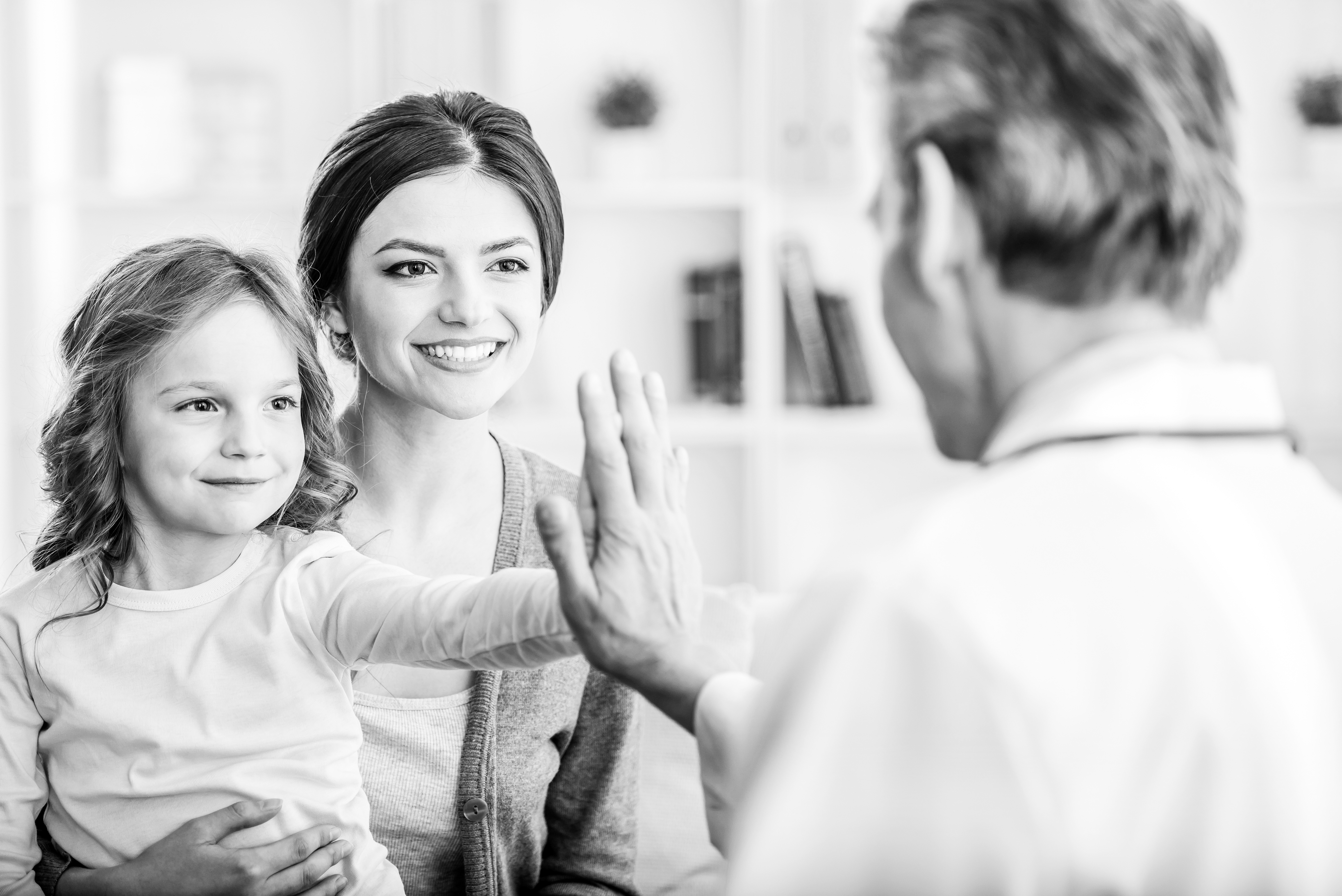 Mother and daughter high-five a healthcare provider