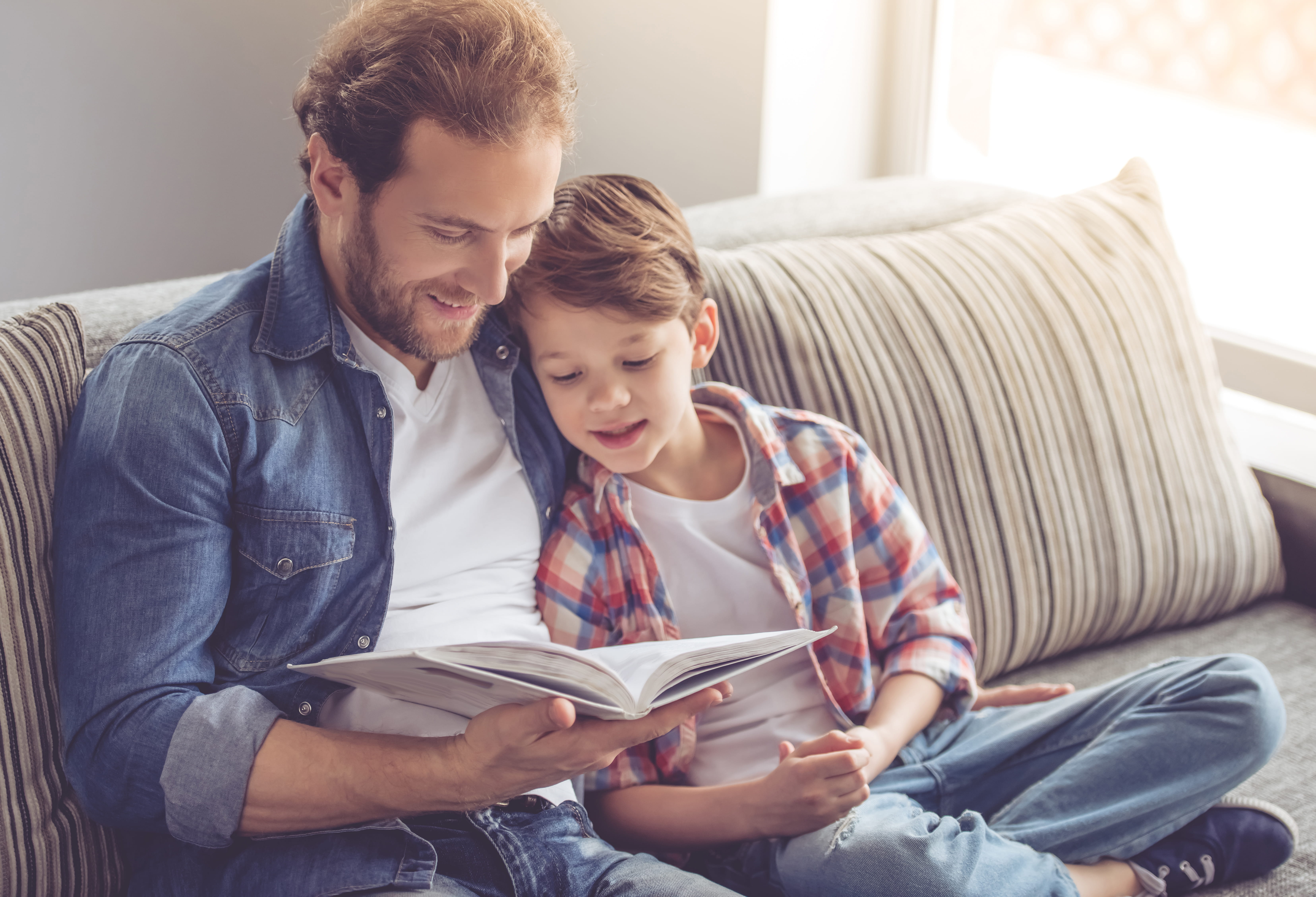 Father and son read a book together